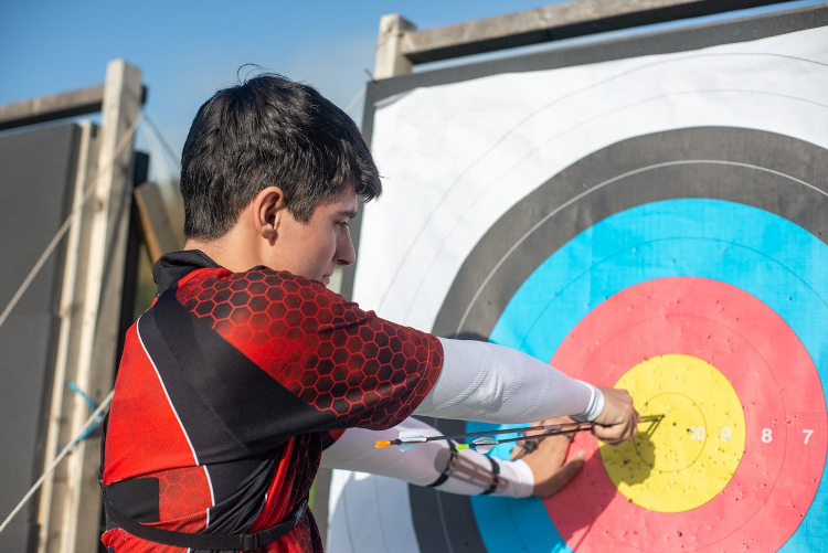 Man pulling an arrow out of a bullseye target