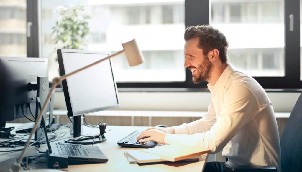 man sitting at a desk looking at his computer