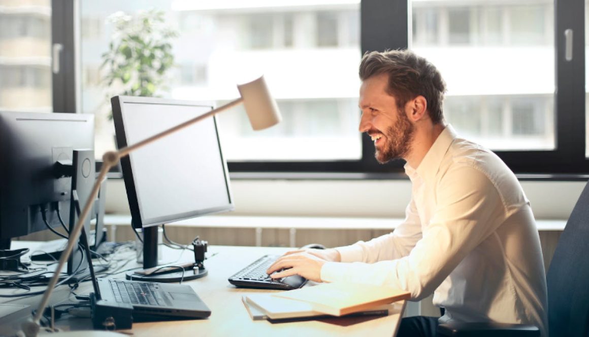 man sitting at a desk looking at his computer