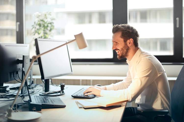 man sitting at a desk looking at his computer